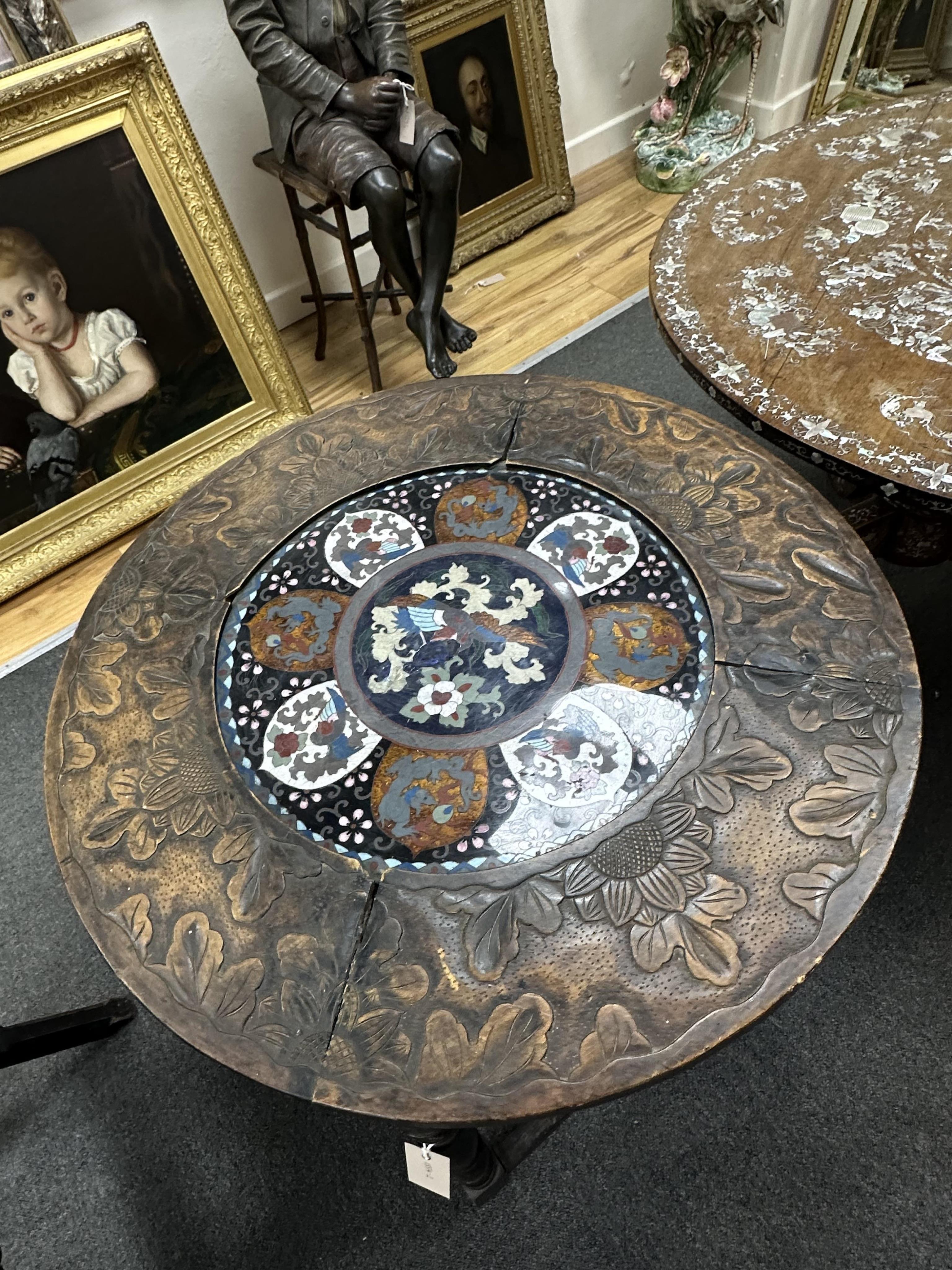 An early 20th century circular carved beech and cloisonne topped occasional table, on oak underframe, diameter 61cm, height 70cm. Condition - fair